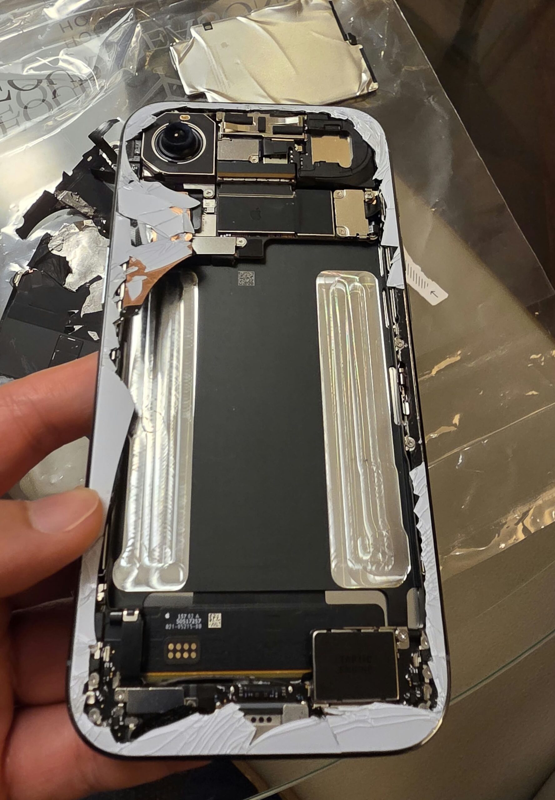 iPhone Air 遭受嚴重跌撞，機背玻璃碎裂剝離，露出內部高密度封裝的主機板屏蔽罩