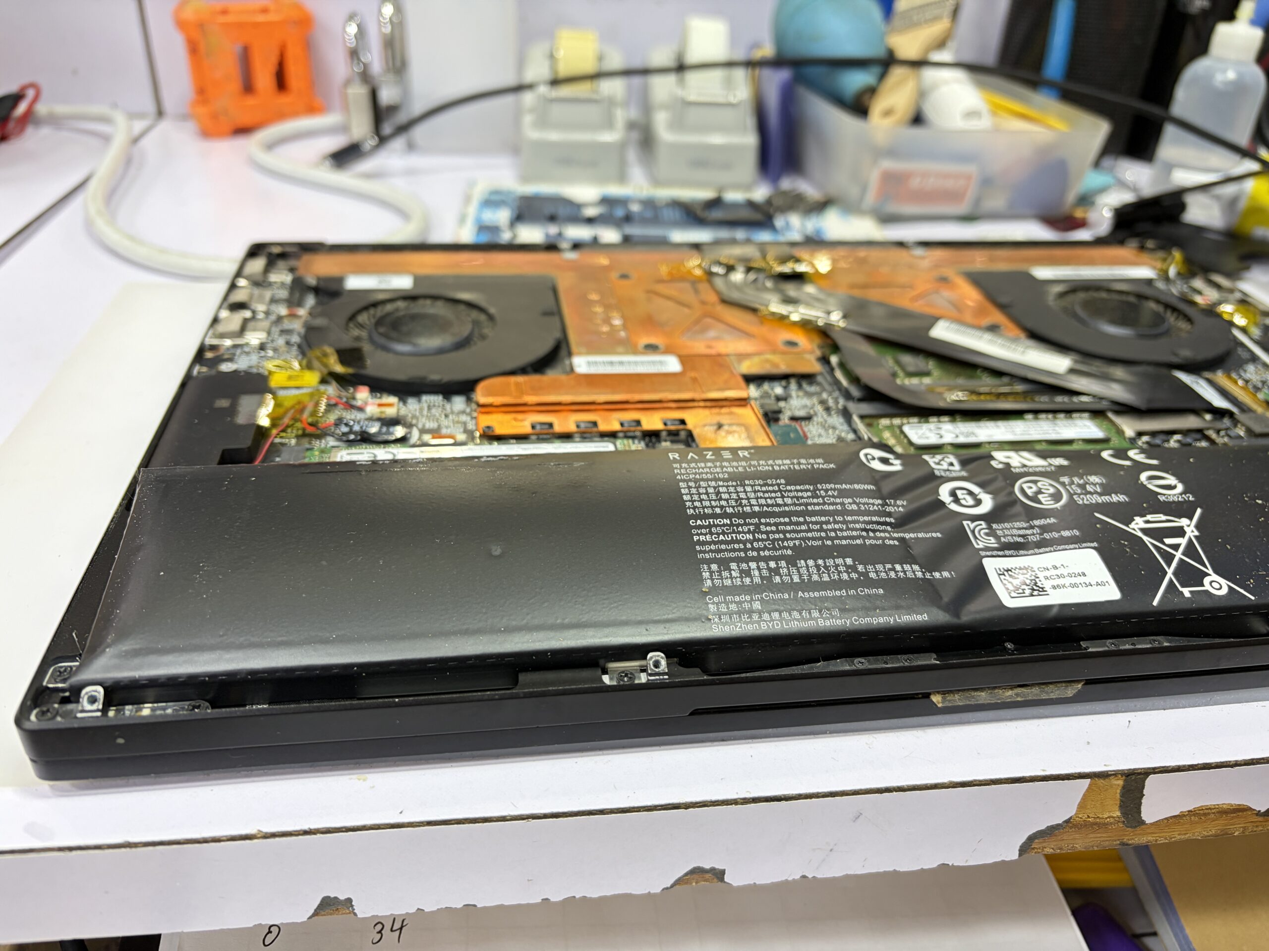 Razer Blade 底蓋拆開後，可見其大型鋰電池已嚴重膨脹（發脹），電池化學反應產生氣體將電芯頂起。它正正位於觸控板下方，形成極大的向上壓迫力。